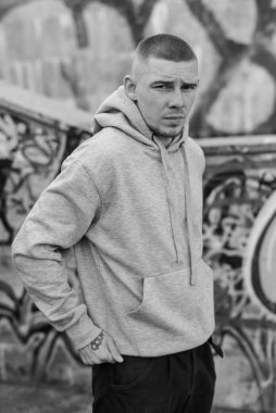 Açık renk spor ceketli, kapüşonlu bir kabadayı. Siyah beyaz fotoğraf. BW