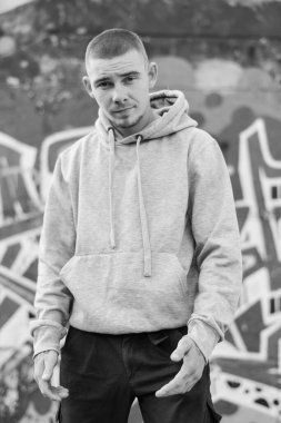 Açık renk spor ceketli, kapüşonlu bir kabadayı. Siyah beyaz fotoğraf. BW