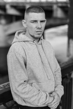 Açık renk spor ceketli, kapüşonlu bir kabadayı. Siyah beyaz fotoğraf. BW