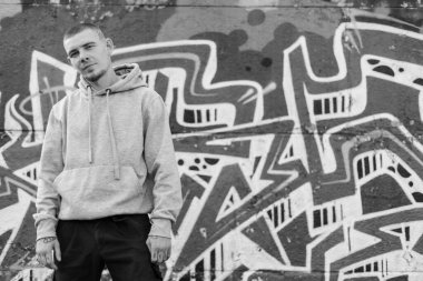 Açık renk spor ceketli, kapüşonlu bir kabadayı. Siyah beyaz fotoğraf. BW