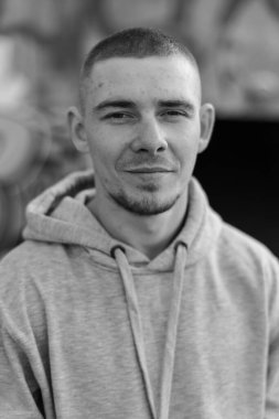 Açık renk spor ceketli, kapüşonlu bir kabadayı. Siyah beyaz fotoğraf. BW