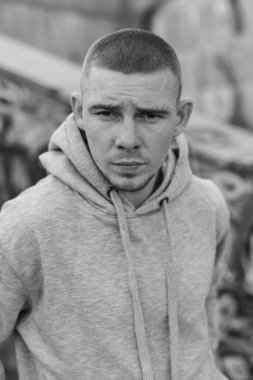 Açık renk spor ceketli, kapüşonlu bir kabadayı. Siyah beyaz fotoğraf. BW