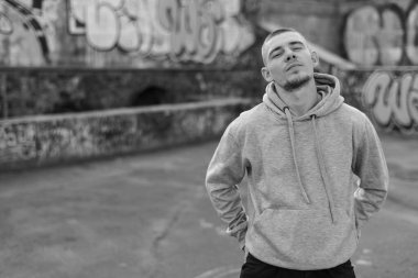 Açık renk spor ceketli, kapüşonlu bir kabadayı. Siyah beyaz fotoğraf. BW