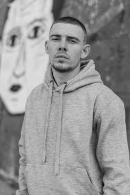 Açık renk spor ceketli, kapüşonlu bir kabadayı. Siyah beyaz fotoğraf. BW