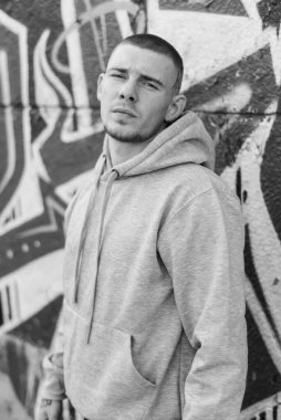 Açık renk spor ceketli, kapüşonlu bir kabadayı. Siyah beyaz fotoğraf. BW