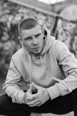 Açık renk spor ceketli, kapüşonlu bir kabadayı. Siyah beyaz fotoğraf. BW