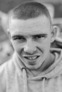 Açık renk spor ceketli, kapüşonlu bir kabadayı. Siyah beyaz fotoğraf. BW