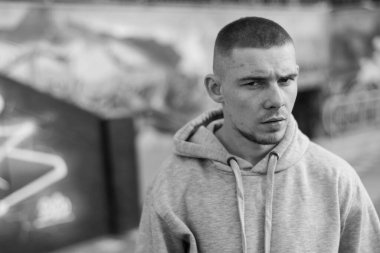 Açık renk spor ceketli, kapüşonlu bir kabadayı. Siyah beyaz fotoğraf. BW