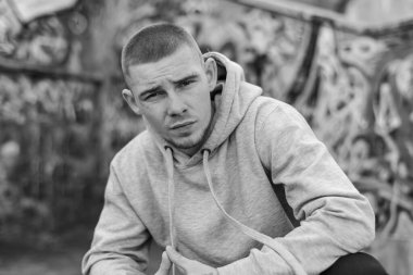 Açık renk spor ceketli, kapüşonlu bir kabadayı. Siyah beyaz fotoğraf. BW