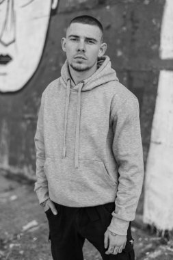 Açık renk spor ceketli, kapüşonlu bir kabadayı. Siyah beyaz fotoğraf. BW