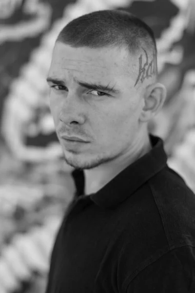 Un joven bravucón con camisa negra. Foto en blanco y negro. BW — Foto de Stock
