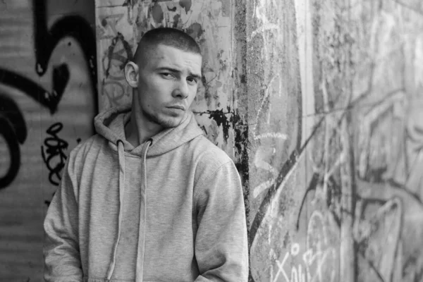 Açık renk spor ceketli, kapüşonlu bir kabadayı. Siyah beyaz fotoğraf. BW