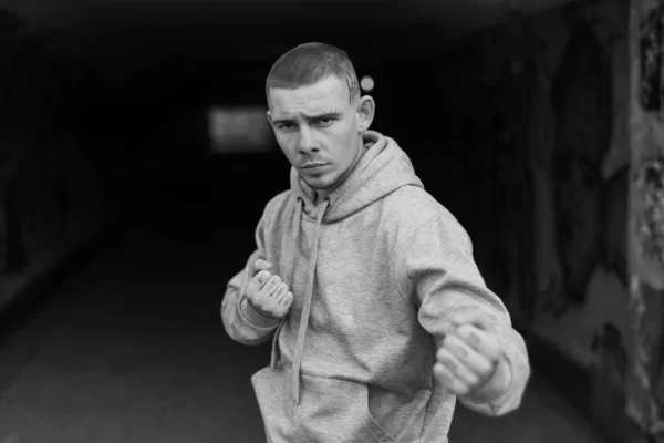 Un matón con una chaqueta deportiva ligera con capucha. Foto en blanco y negro. BW —  Fotos de Stock