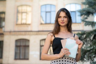 Üniversitenin yakınında defteri ve kitabı olan genç bir kız öğrenci. Kyiv, Ukrayna