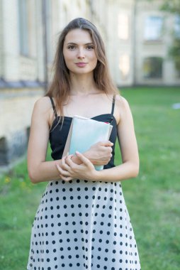 Üniversitenin yakınında defteri ve kitabı olan genç bir kız öğrenci. Kyiv, Ukrayna