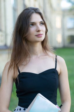 Üniversitenin yakınında defteri ve kitabı olan genç bir kız öğrenci. Kyiv, Ukrayna