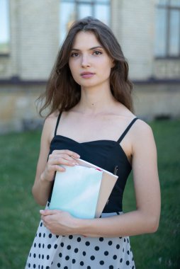 Üniversitenin yakınında defteri ve kitabı olan genç bir kız öğrenci. Kyiv, Ukrayna