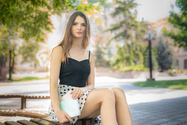 Menina estudante com um livro e um caderno em um banco perto da universidade. Kiev. Ucrânia — Fotografia de Stock