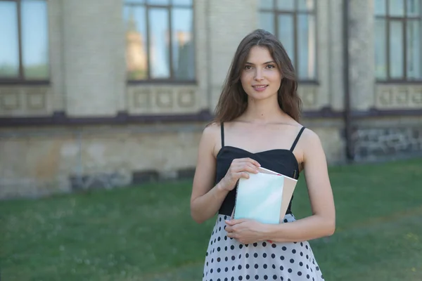 Ung flicka student med bok och anteckningsbok nära universitetet. Kiev, Ukraina — Stockfoto