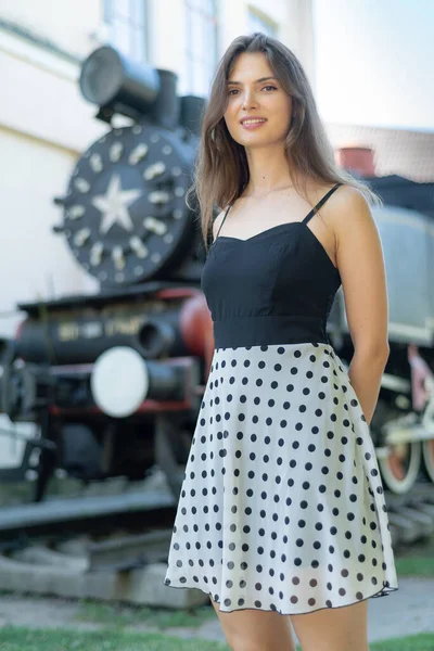 Krásná mladá dívka v bílo-černé šaty s puntíky polka — Stock fotografie