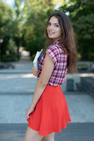 Estudante menina em saia vermelha e camisa xadrez — Fotografia de Stock