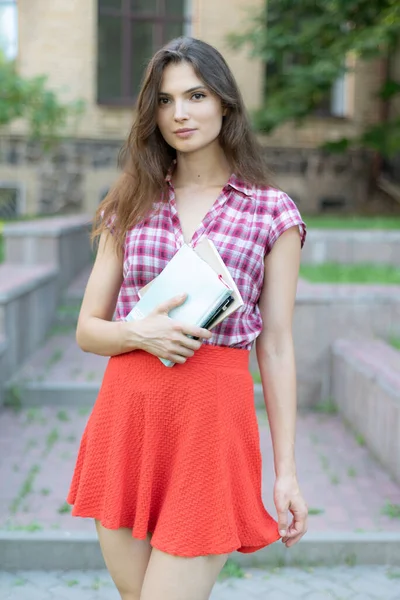 Dziewczyna student w czerwonej spódnicy i koszuli w kratę — Zdjęcie stockowe