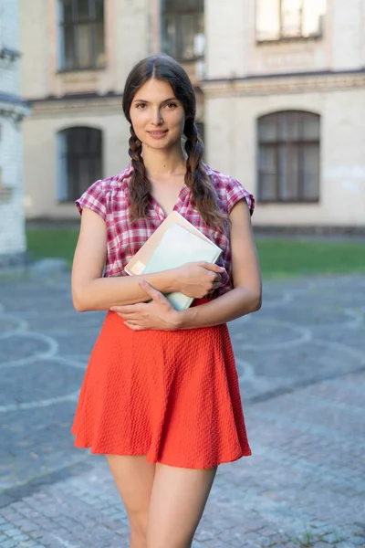 Студентка в красной юбке и клетчатой рубашке — стоковое фото