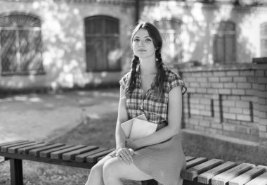 Bankta genç bir kız öğrenci. Siyah beyaz fotoğraf. BW