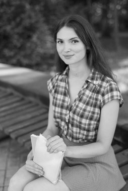 Bankta genç bir kız öğrenci. Siyah beyaz fotoğraf. BW