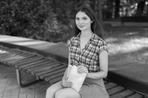 Ung flicka student på en bänk. Svart och vitt foto. BW — Stockfoto