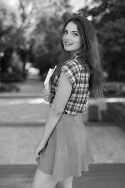 Chica estudiante en falda y camisa a cuadros. Foto en blanco y negro. BW —  Fotos de Stock