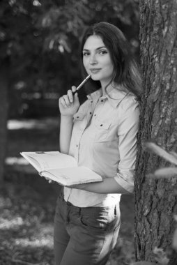 Kalemi olan genç bir kız öğrenci. Siyah beyaz fotoğraf. BW