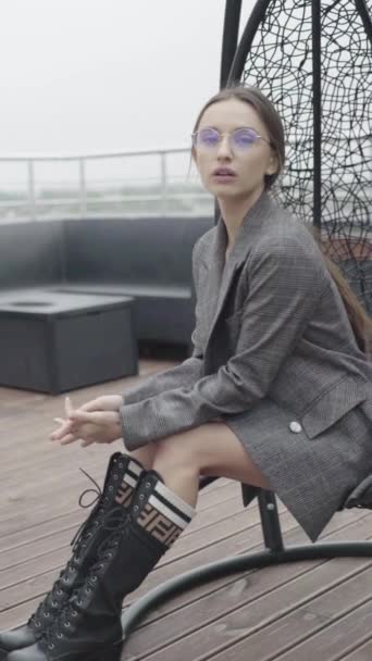 Vertikales Video. Schönes Mädchen mit Brille und grauem Anzug. Zeitlupe — Stockvideo