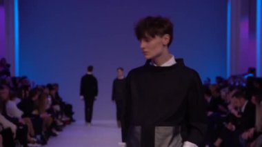 Moda gösterisi. Erkek manken podyumda yürüyor..