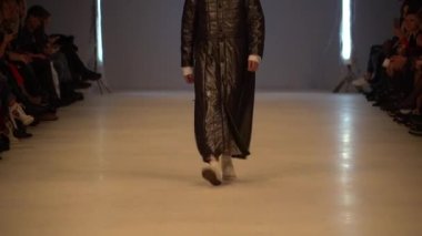 Moda gösterisi. Erkek manken podyumda yürüyor..