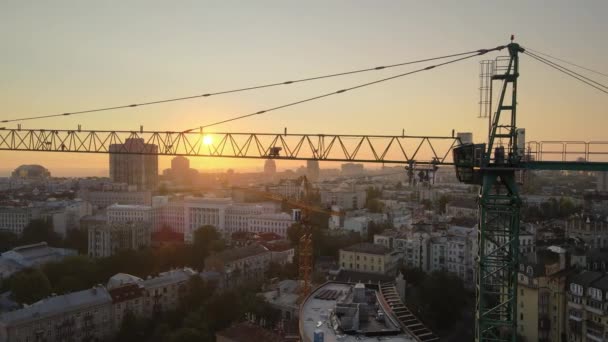 Grúa de construcción en una obra de construcción en la ciudad al amanecer. Kiev, Ucrania. Vista aérea — Vídeos de Stock