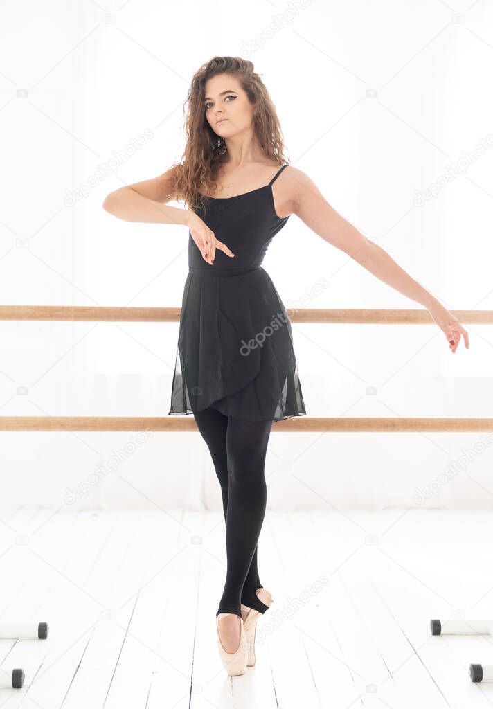 Young beautiful girl ballerina with curly hair