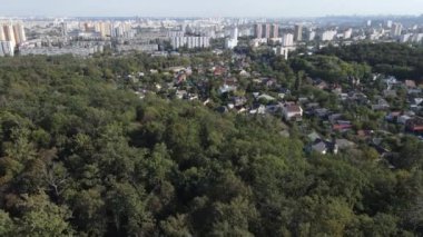 Ormanın yanındaki Megalopolis: Büyük şehirle doğa arasındaki bağlantı. Hava görüntüsü. Yavaş çekim
