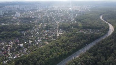 Ormanın yanındaki Megalopolis: Büyük şehirle doğa arasındaki bağlantı. Hava görüntüsü. Yavaş çekim