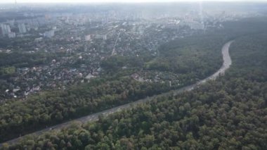Ormanın yanındaki Megalopolis: Büyük şehirle doğa arasındaki bağlantı. Hava görüntüsü. Yavaş çekim