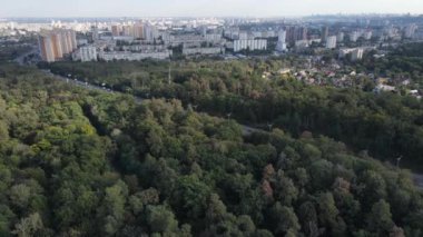 Ormanın yanındaki Megalopolis: Büyük şehirle doğa arasındaki bağlantı. Hava görüntüsü. Yavaş çekim