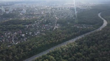 Ormanın yanındaki Megalopolis: Büyük şehirle doğa arasındaki bağlantı. Hava görüntüsü. Yavaş çekim