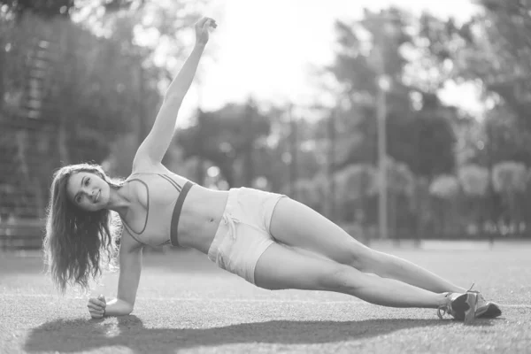 Sport a zdravý životní styl: Bruneta dívka dělá sportovní cvičení. Černobílá fotka. BW — Stock fotografie