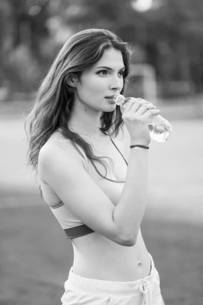Meisje atleet drinkt water tijdens een pauze in de sport. Zwart-wit foto. BW — Stockfoto