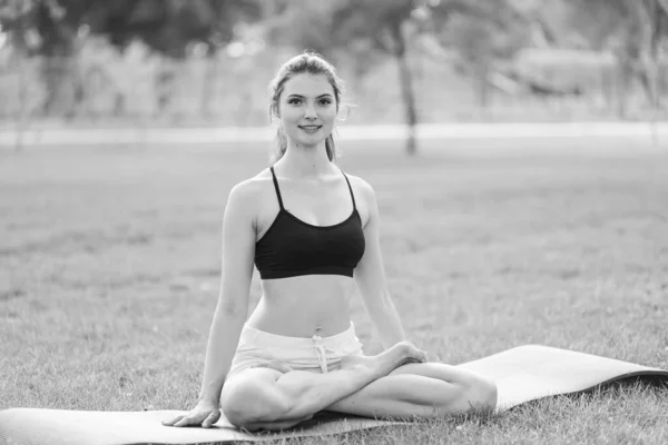 Mädchen machen tagsüber Yoga im Park. Schwarz-Weiß-Foto. BW — Stockfoto