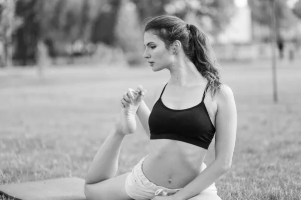 Mädchen machen tagsüber Yoga im Park. Schwarz-Weiß-Foto. BW — Stockfoto