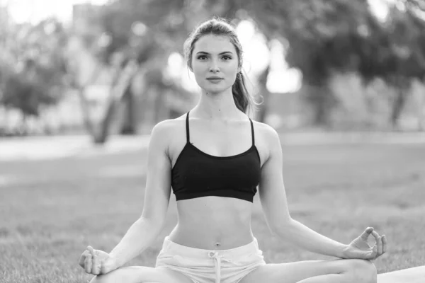 Mädchen machen tagsüber Yoga im Park. Schwarz-Weiß-Foto. BW — Stockfoto