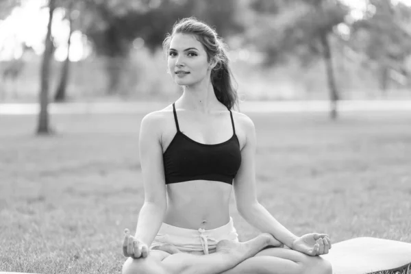 Mädchen machen tagsüber Yoga im Park. Schwarz-Weiß-Foto. BW — Stockfoto