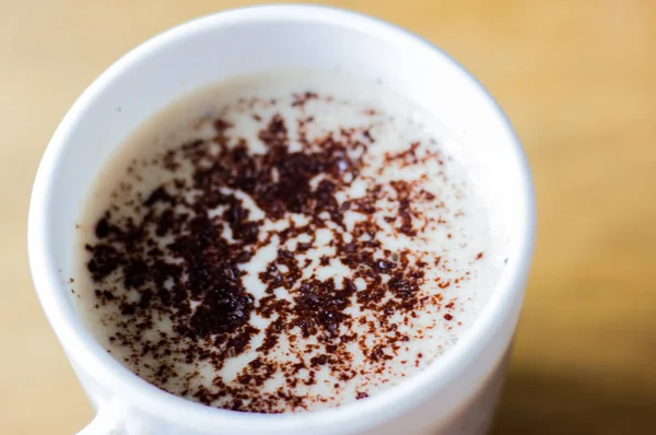 咖啡加泡沫和巧克力杯在一个白色杯子里 卡布奇诺在一个白色的杯子 早上好 早上的卡布奇诺早餐 杯子顶视图中的咖啡 一杯咖啡的宏观镜头 — 图库照片
