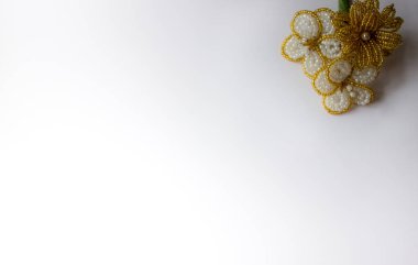 Beyaz arka planda altın boncuk çiçekleri. Sağ üst köşede altın çiçekler..
